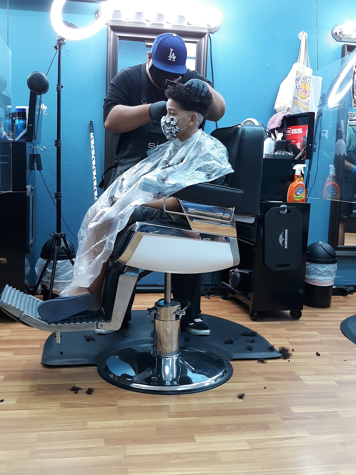 A barber working on a young client in the chair at the Norwalk shop