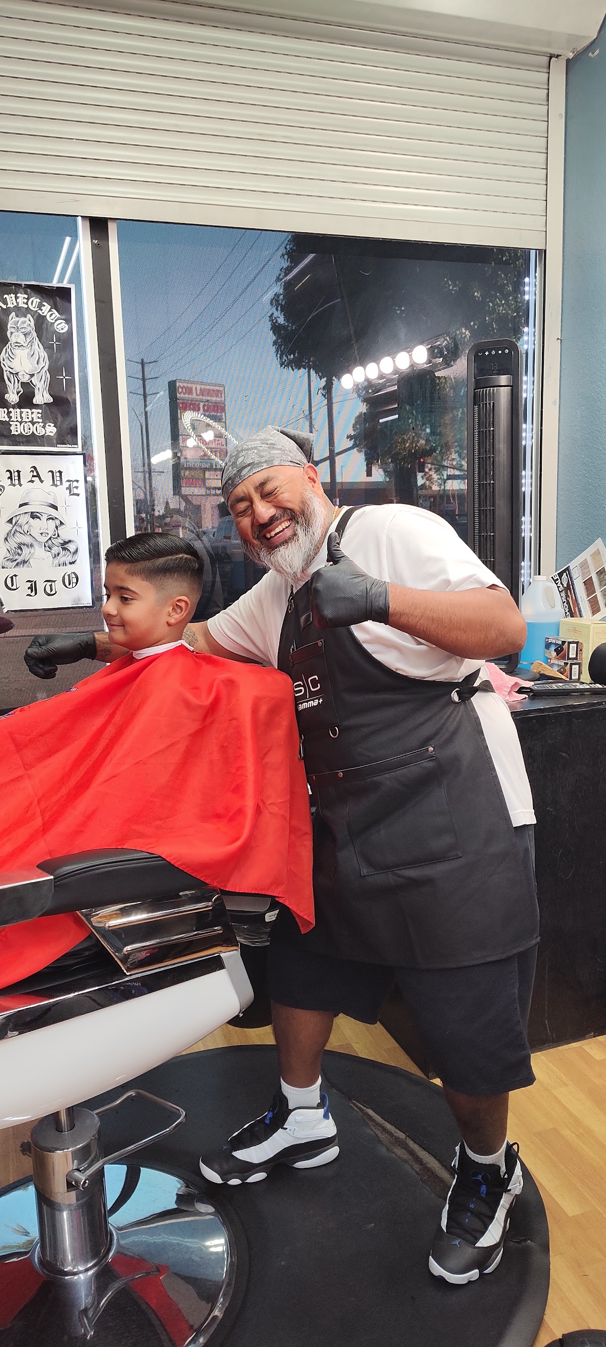 A barber at So. Cal. Barber's giving a thumbs up next to a client with a fresh comb over fade